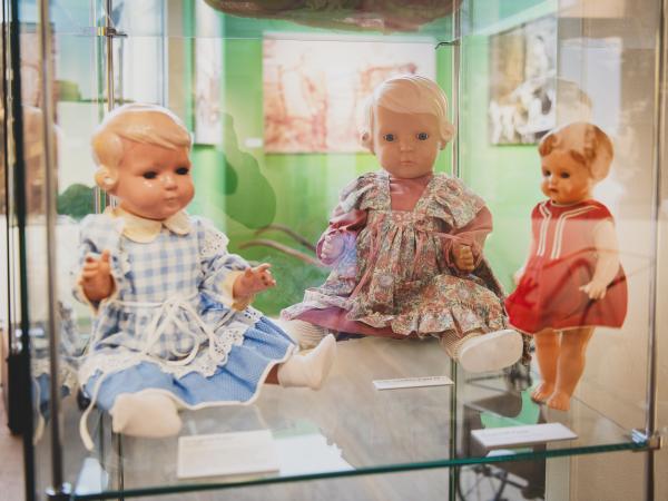 Verschiedene Puppen in einer Glasvitrine