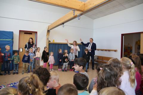 Der Bürgermeister und mehrere Kinder singen ein Lied zusammen.
