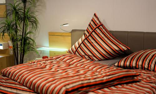 Ein Bett in einem Hotelzimmer mit gestreifter Decke und Kissen