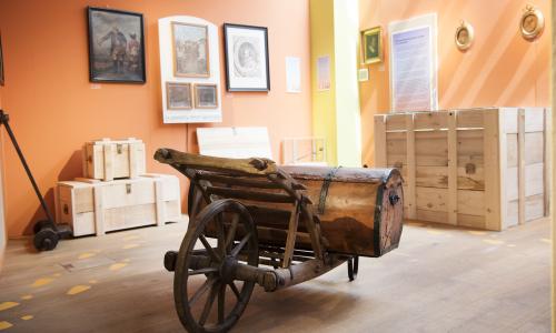 Blick in die Ausstellung mit altem Karren und weiteren Objekten