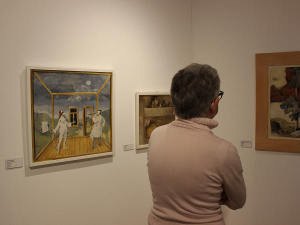 Ein Besucher betrachtet ein Gemälde an der Wand