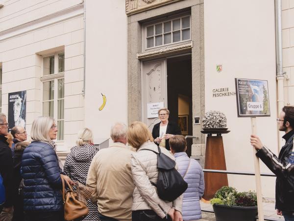 Eine Gruppe steht vor der Galerie Peschkenhaus.