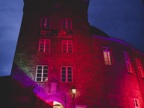 Das Moerser Schloss bunt beleuchtet und ein geschnitzter Kürbis.