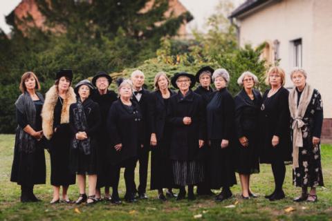 Eine Gruppe von Frauen steht nebeneinander in schwarzer Kleidung.