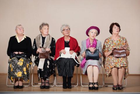 Eine Gruppe von Frauen sitzt auf Klappstühlen und schaut nach rechts.