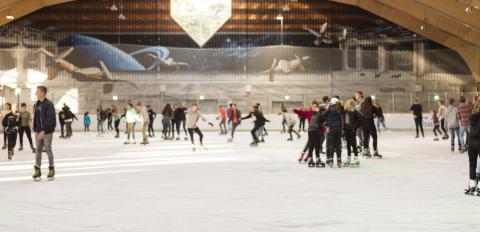 Die Eissporthalle mit mehreren Personen von innen.