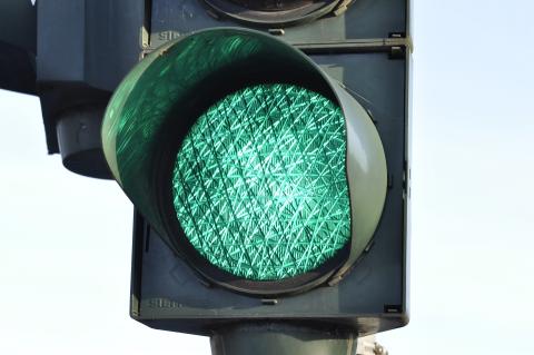 Eine Bildvergrößerung an das grüne Lichtsignal einer Ampel.