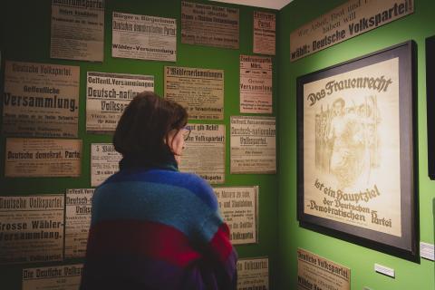 Besucherin in der Ausstellung vor dem Plakat: Das Frauenrecht