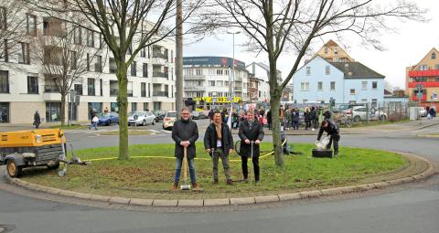 Drei Personen stehen auf dem Kreisverkehr an der Homberger Straße.