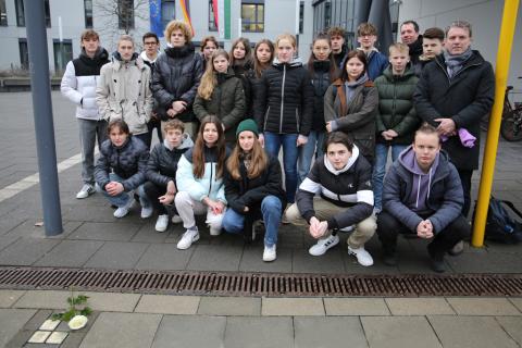 Eine Gruppe von Schülern mit dem Bürgermeister vor dem Rathaus.
