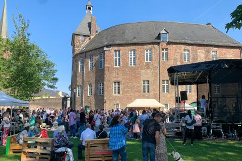 Eine Bühne und viele Menschen vor dem Moerser Schloss.