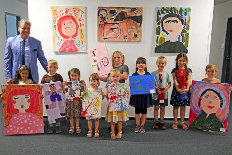 Kinder vom Kindergarten sind mit ihren Bildern beim Bürgermeister Cristoph Fleischhauer im Büro